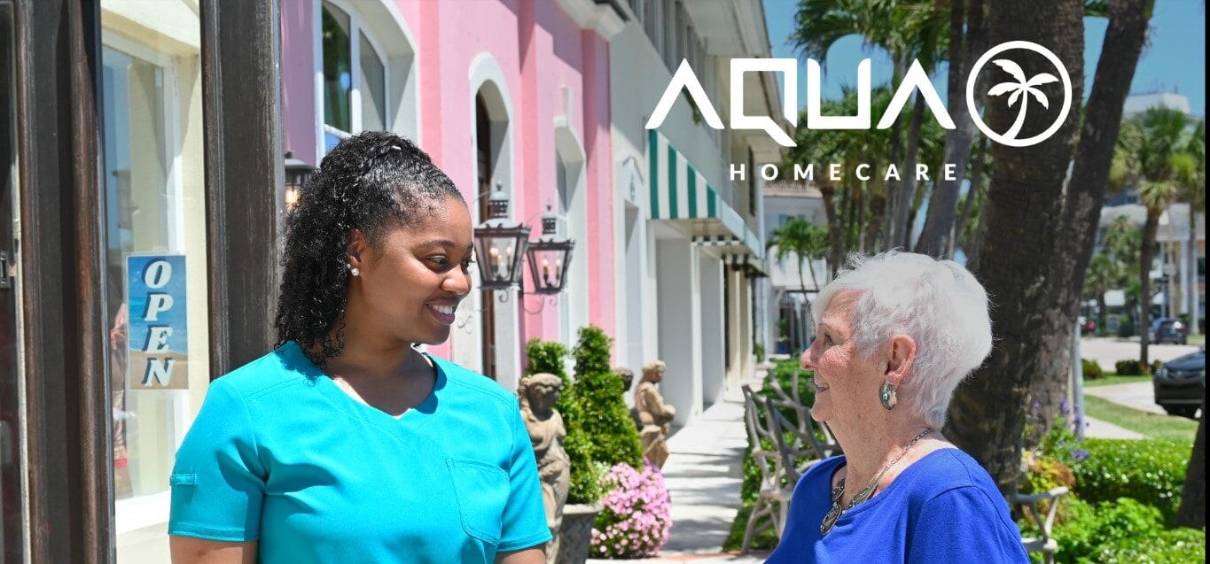 A caregiver and a senior woman chatting outside Aqua Home Care in Miami.