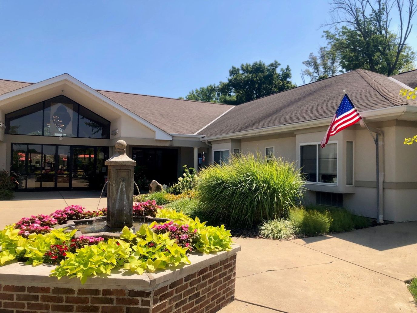 Front entrance of the facility with landscaping and flag