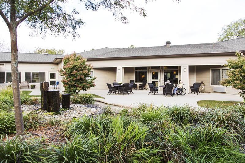 Outdoor area with seating and greenery at assisted living facility