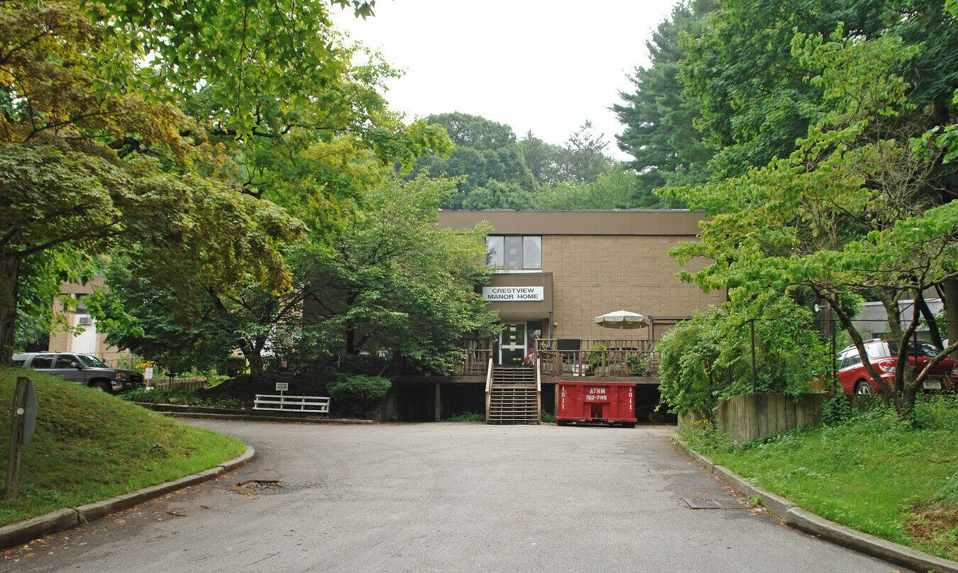 Exterior view of Crestview Manor ALF surrounded by greenery