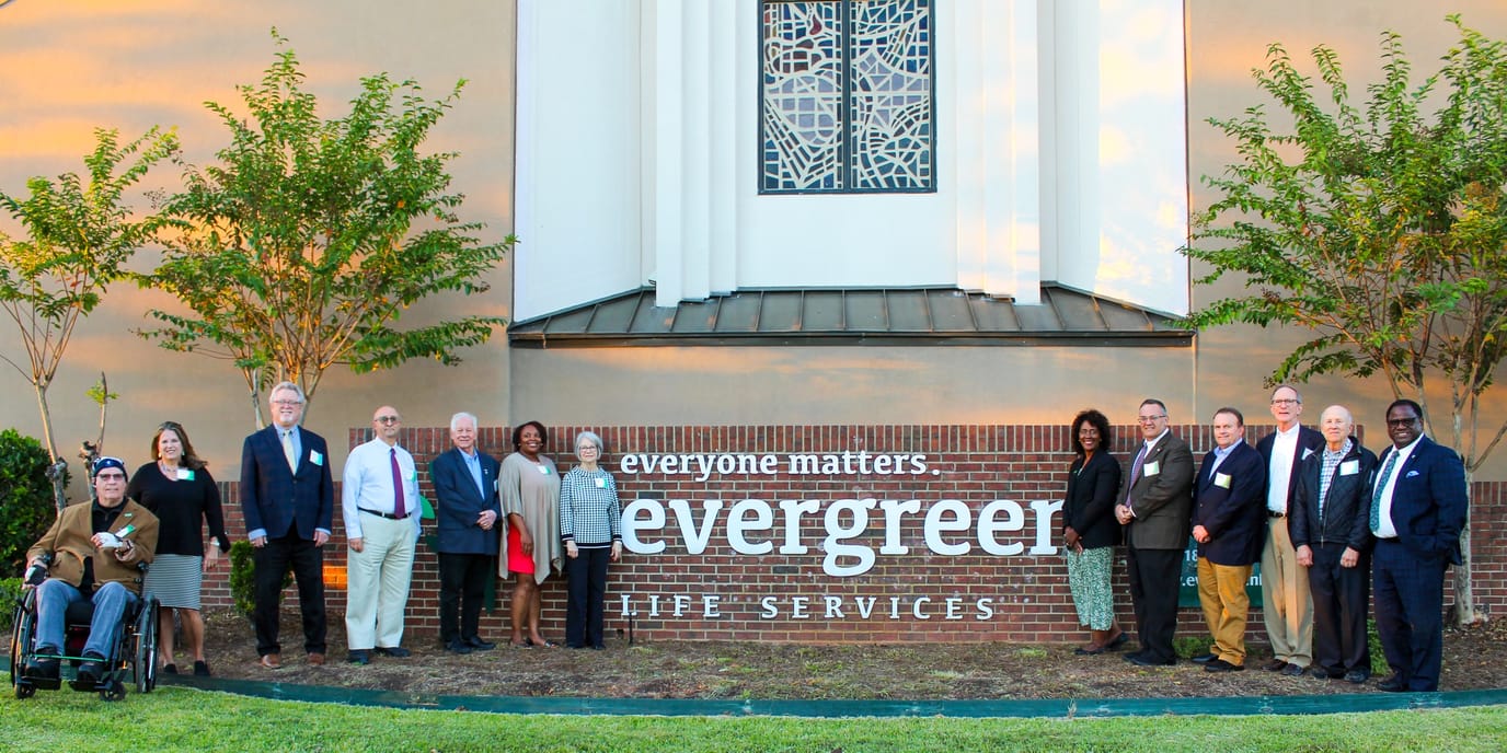 Group photo of staff and visitors in front of Evergreen Life Services building