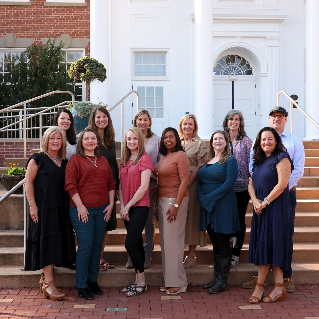 Staff members posing outside the facility entrance