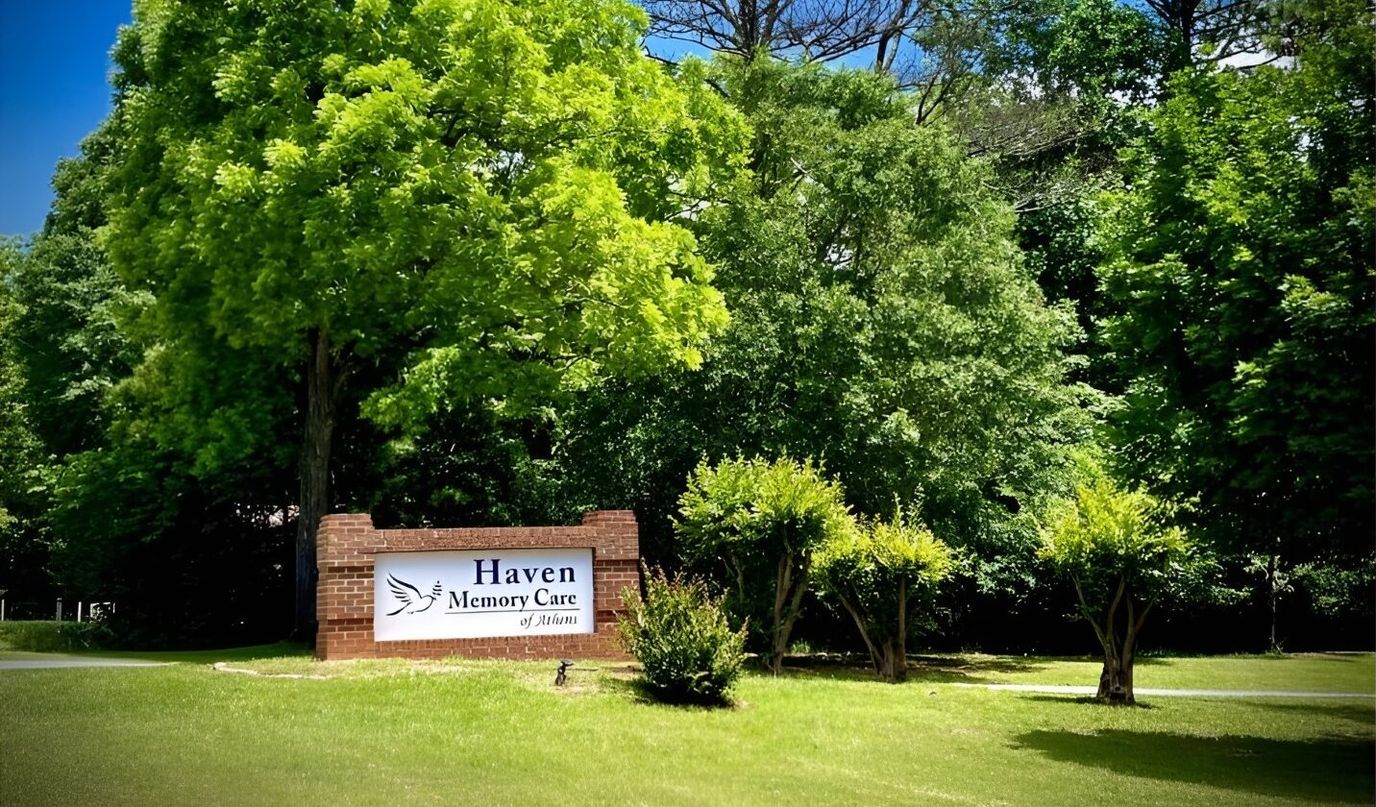 Signage for Haven Memory Care Community surrounded by greenery