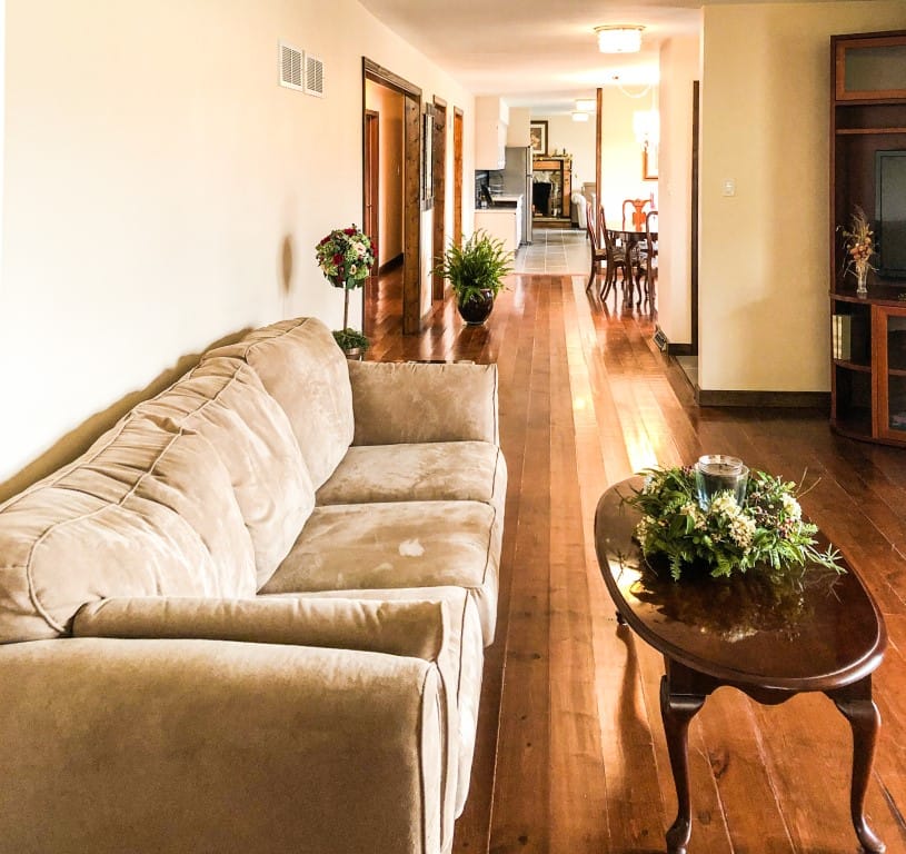 Bright common area with cozy seating and wooden floors
