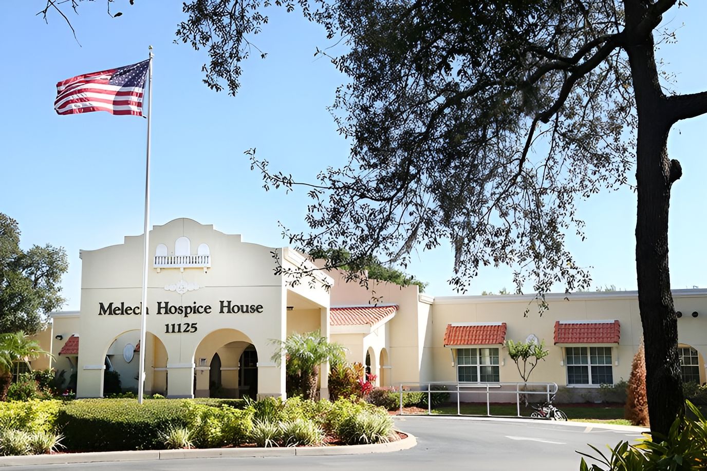 Exterior view of Melech Hospice House with flag