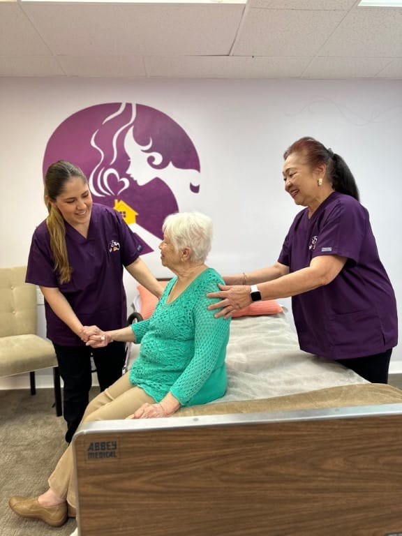 Staff assisting a senior resident in a cozy common area