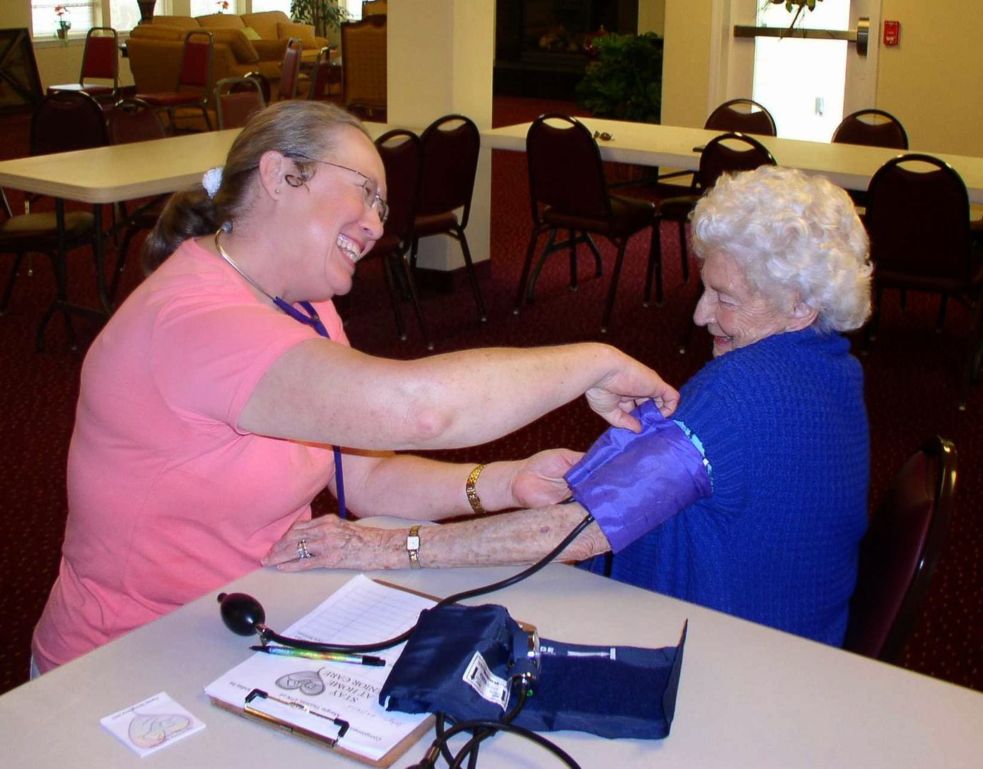 Staff member checking blood pressure of a senior resident