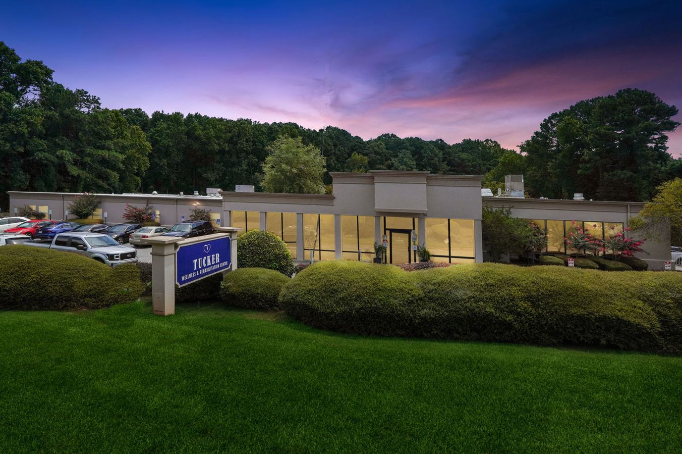 Exterior view of Tucker Nursing & Rehab Center during sunset
