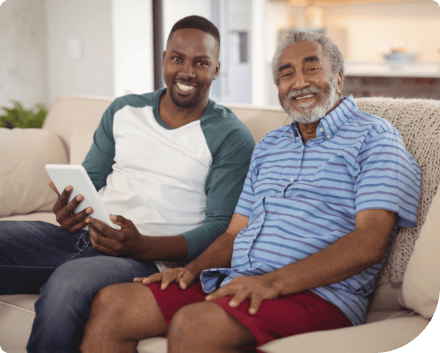 Two smiling men sitting on a couch