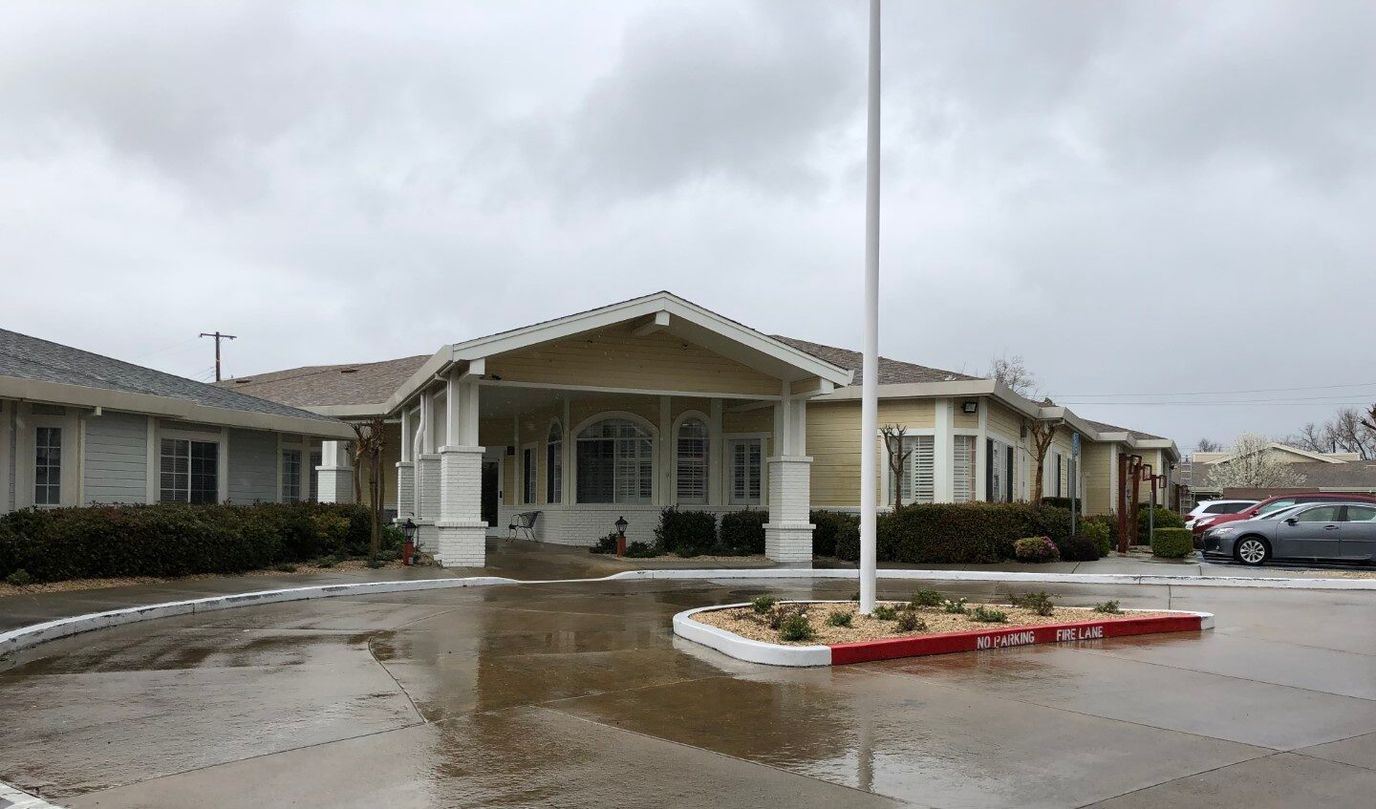 Building exterior of a senior living facility under cloudy skies