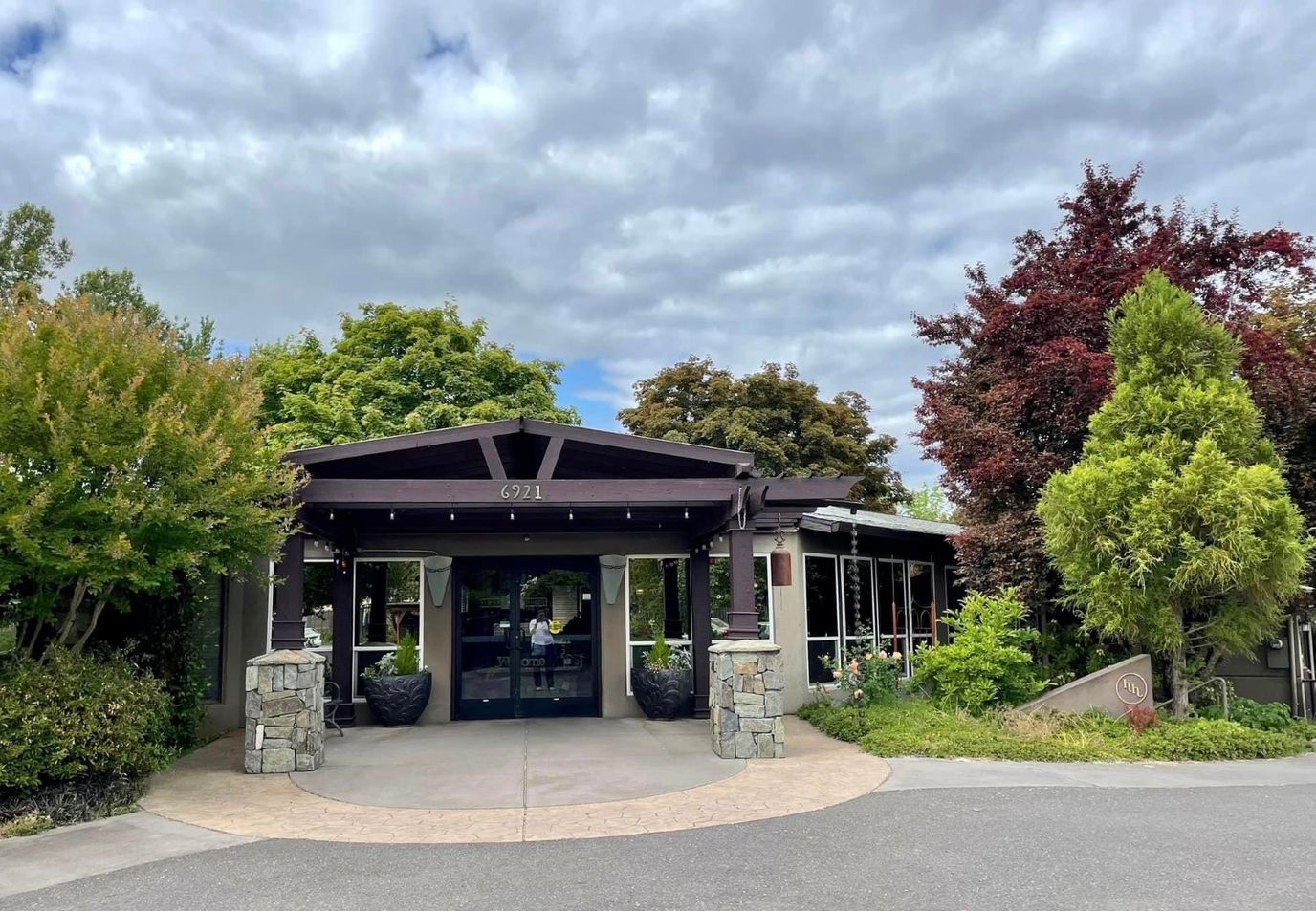 Exterior view of a senior living facility entrance with landscaping