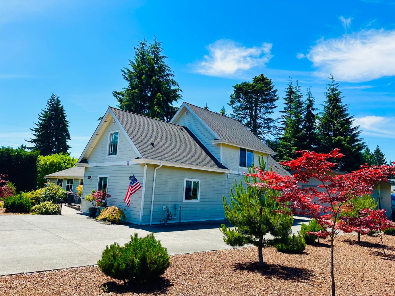 Exterior view of a senior care facility with trees and flowers