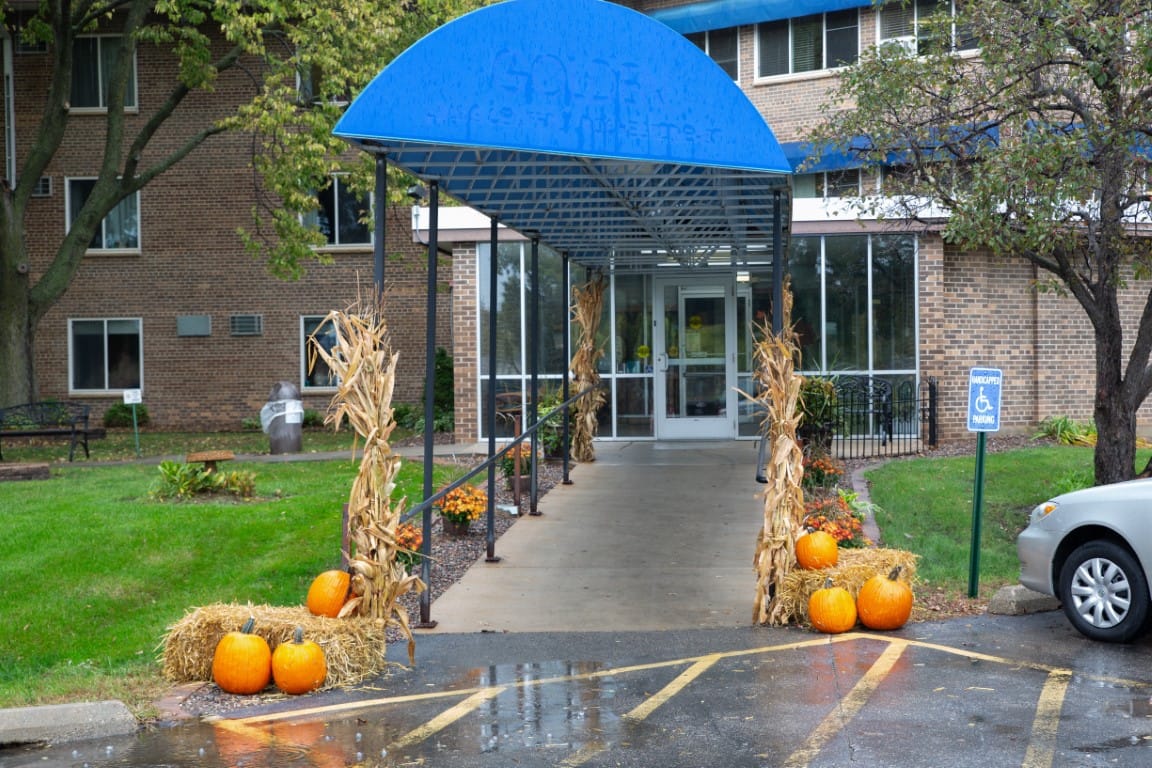 Entrance with decorative pumpkins and corn stalks