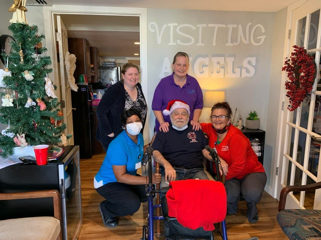 Staff and residents smiling together in a festive hallway