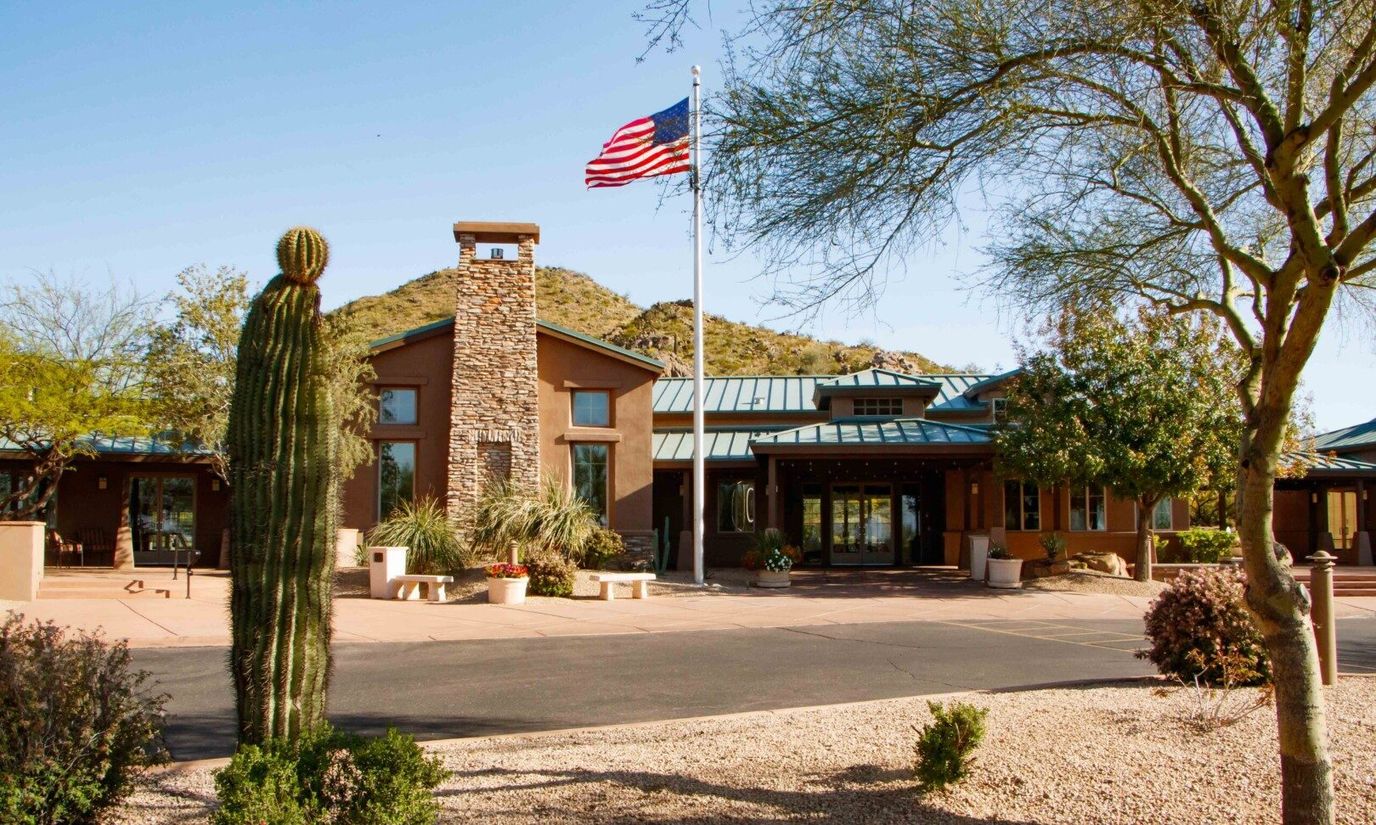 Exterior view of Solera at Johnson Ranch with garden and flag