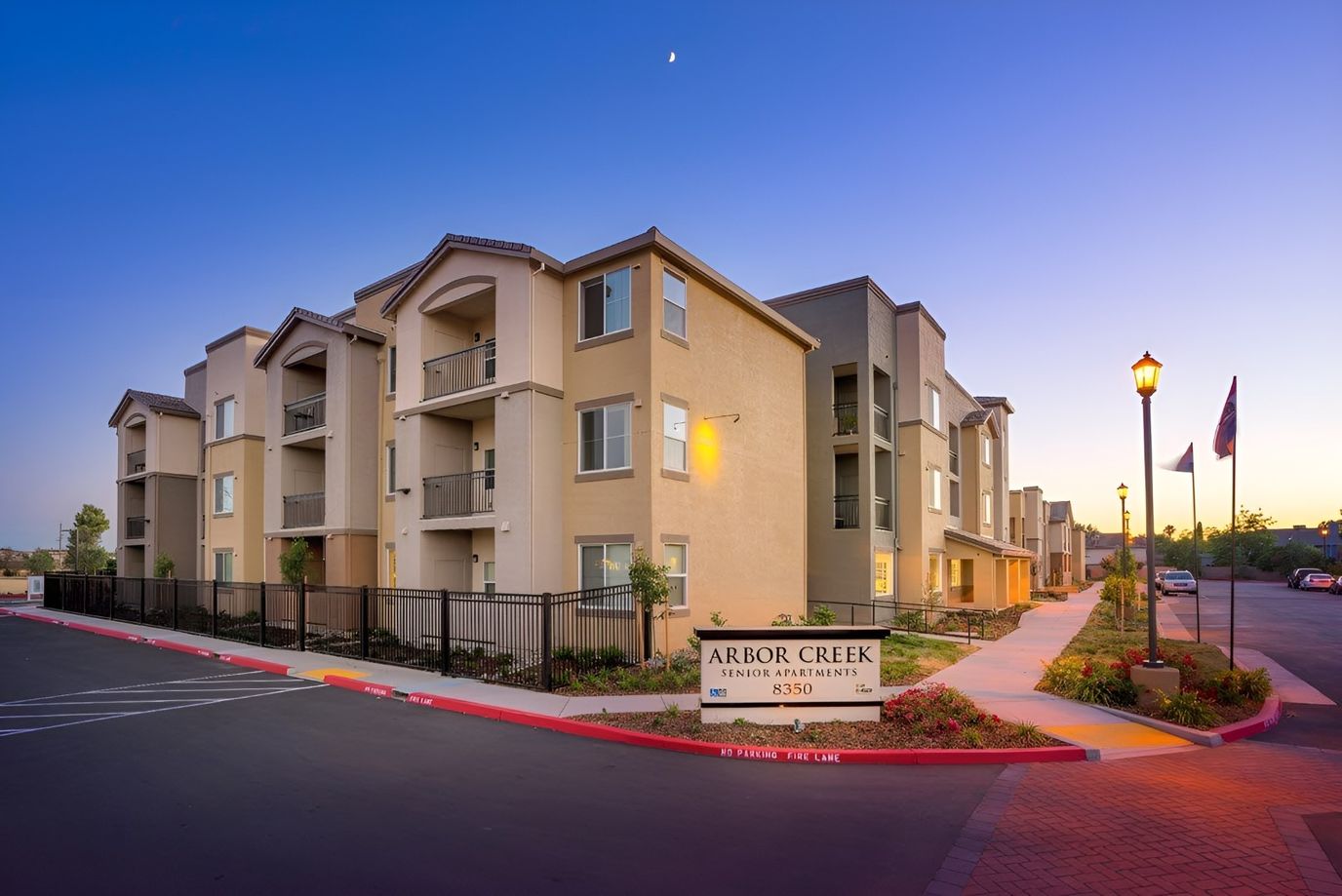 Exterior view of Arbor Creek Senior Apartments at dusk