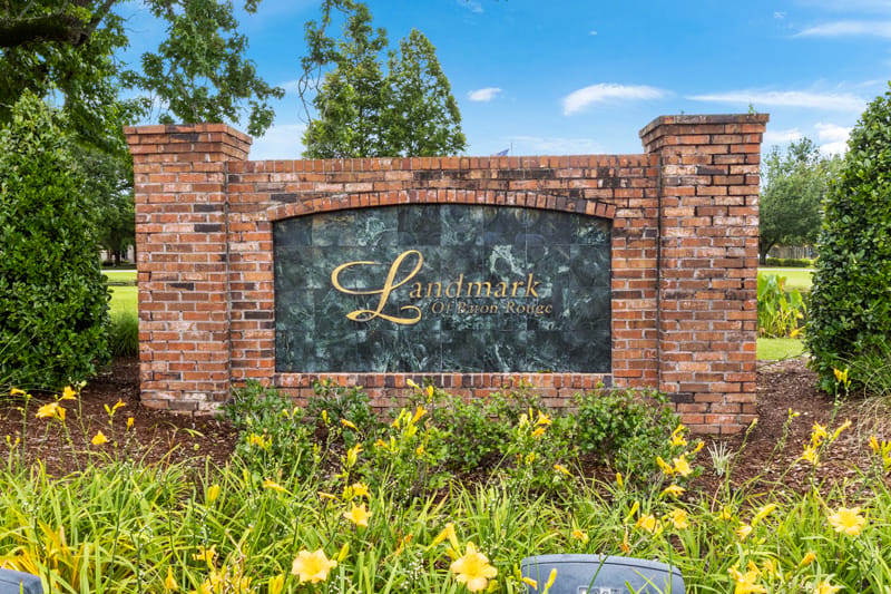 Exterior sign of Landmark of Baton Rouge surrounded by flowers