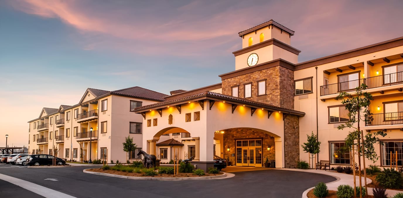 Exterior view of a senior living facility at sunset