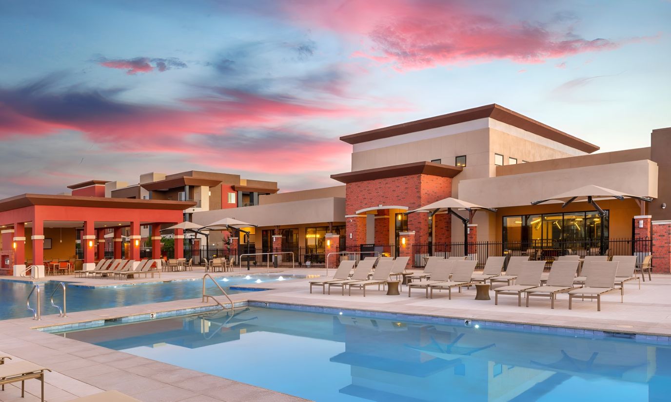 Exterior view of a swimming pool and building at sunset