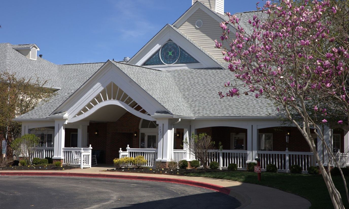 Entrance of a senior living facility with blooming trees