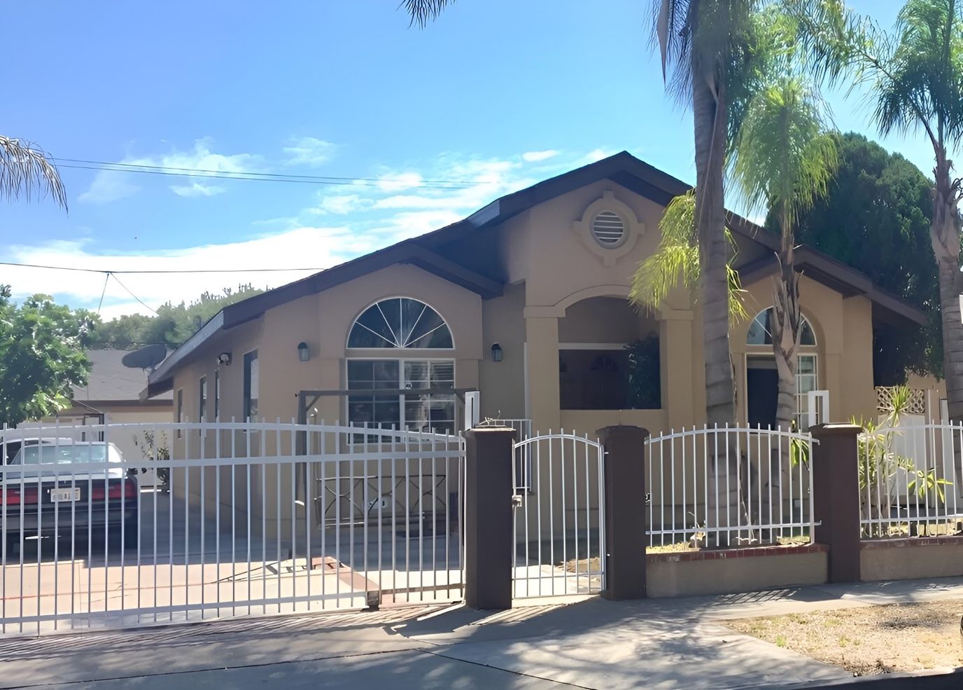 Front view of a senior living facility with palm trees