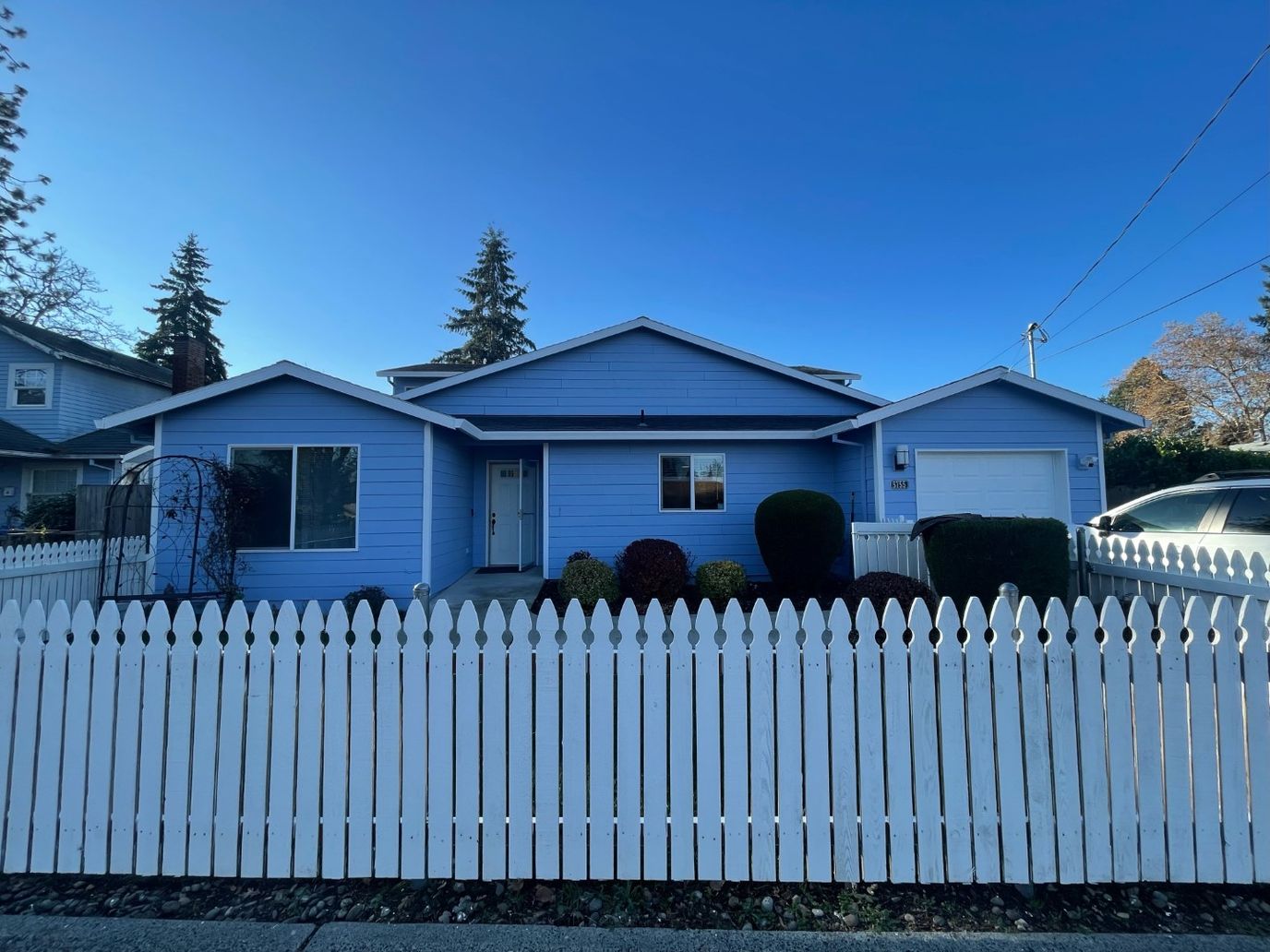 Exterior view of a blue residential building with a white fence