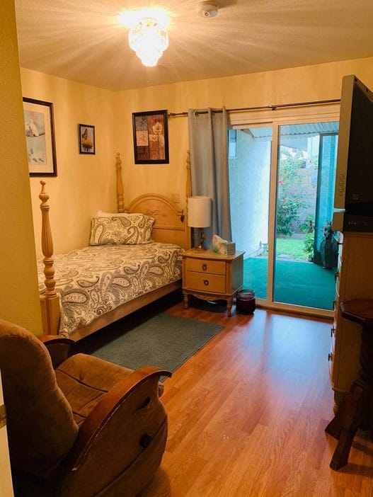 A cozy resident room with a bed and sitting area