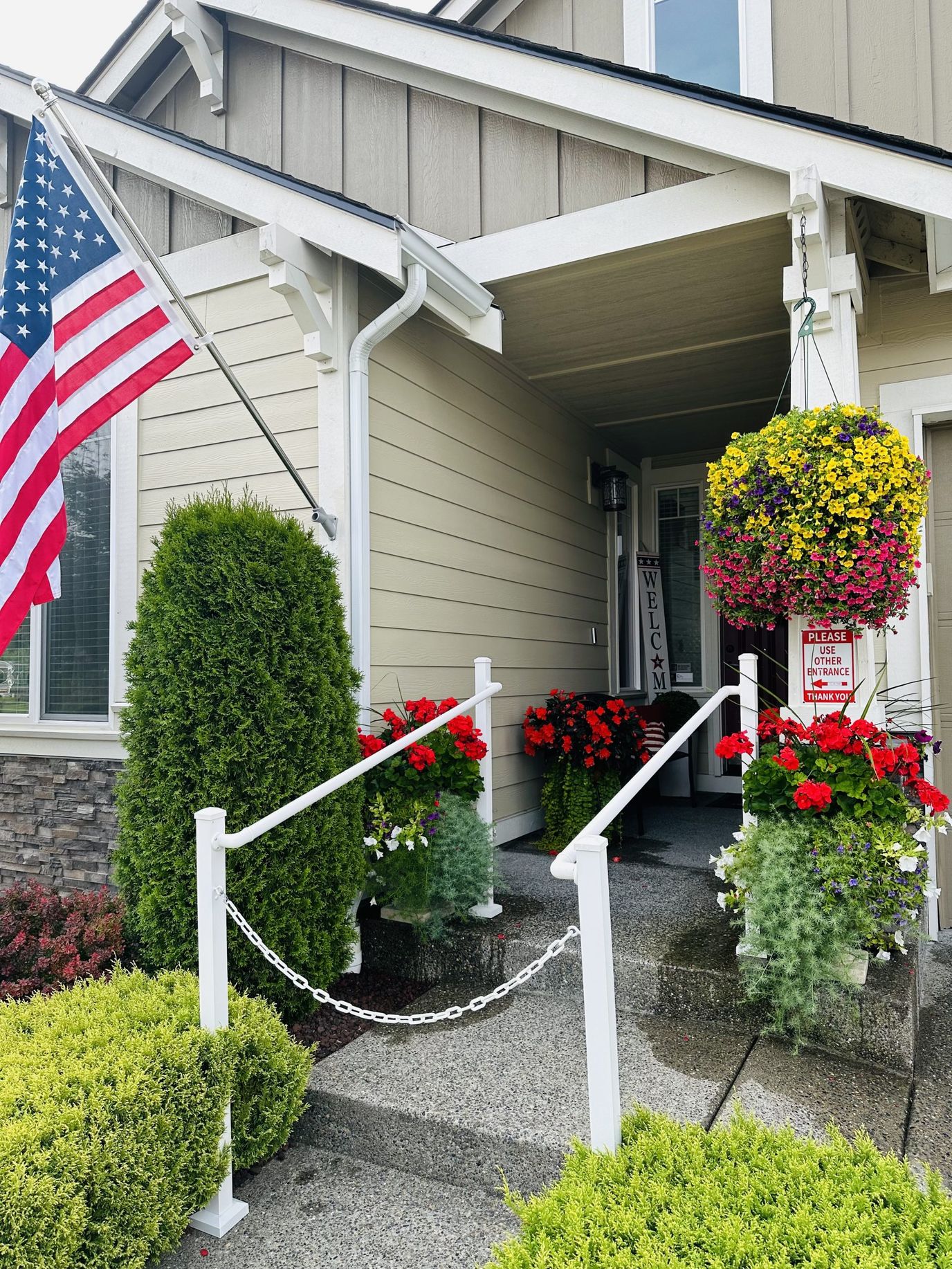 Welcoming front porch with flowers and American flag