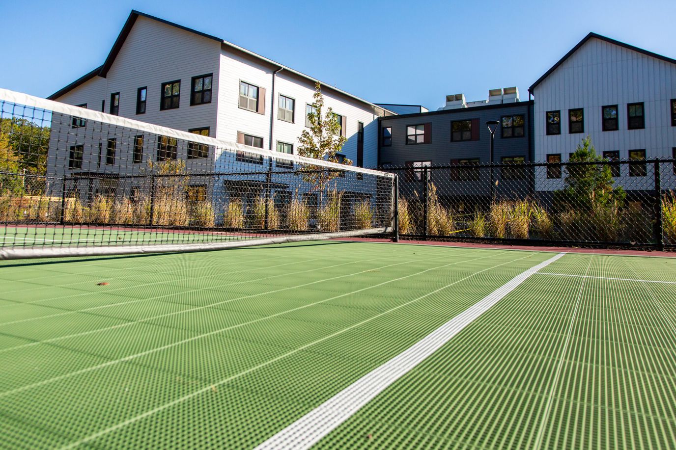 Outdoor tennis courts with residential buildings in the background