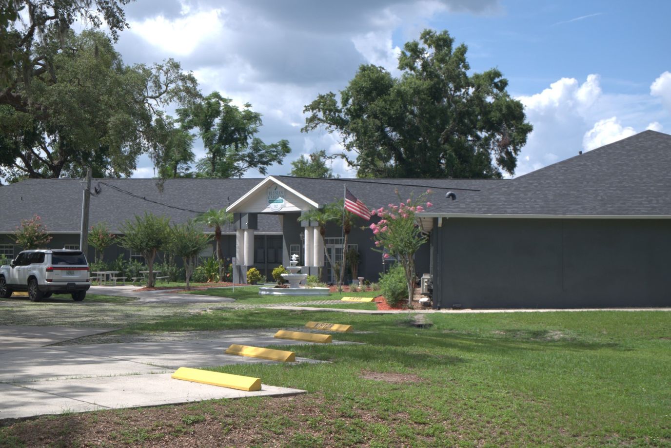 Exterior view of Elysian Gardens Assisted Living Facility with gardens