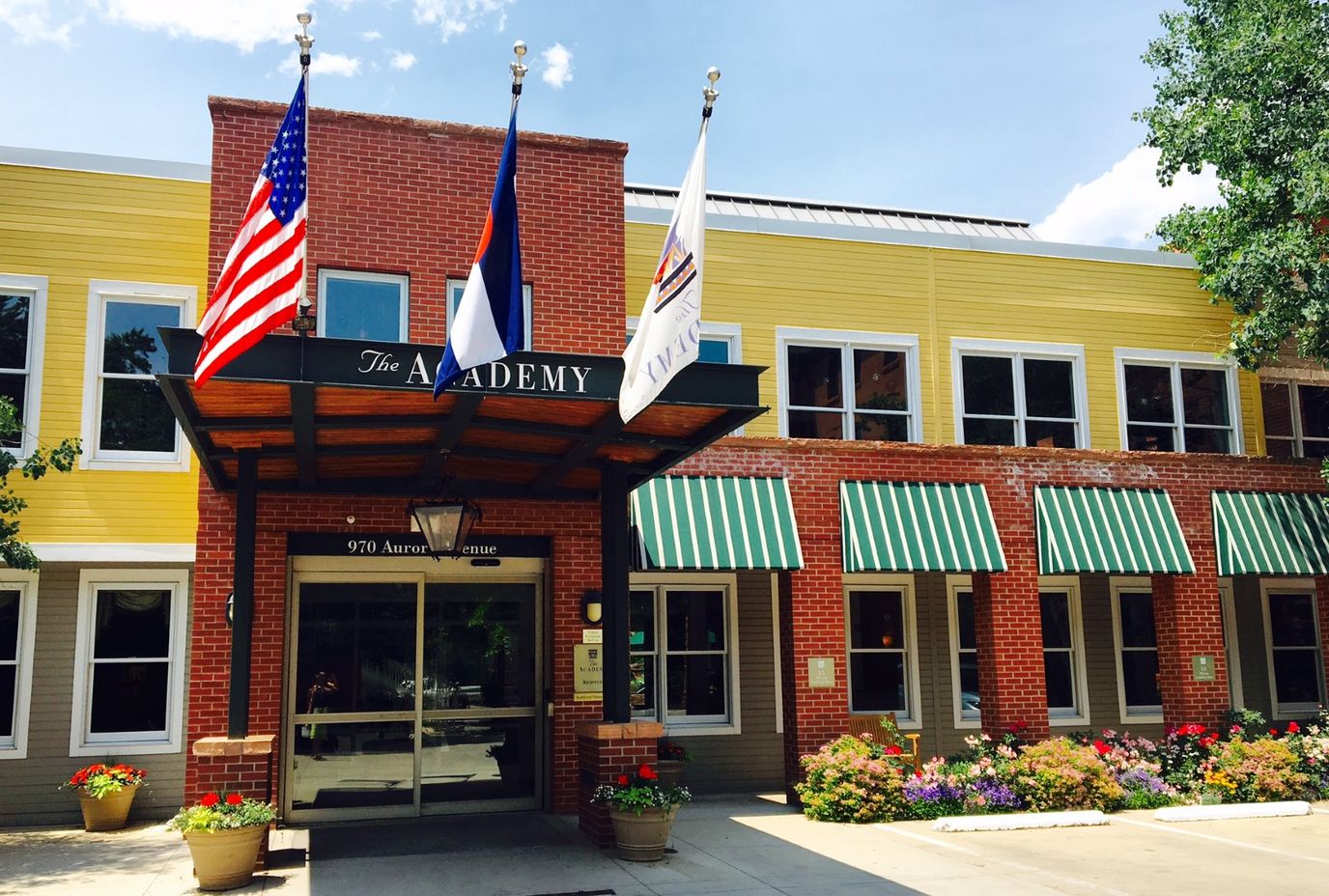 Exterior view of The Academy facility with flags and flowers