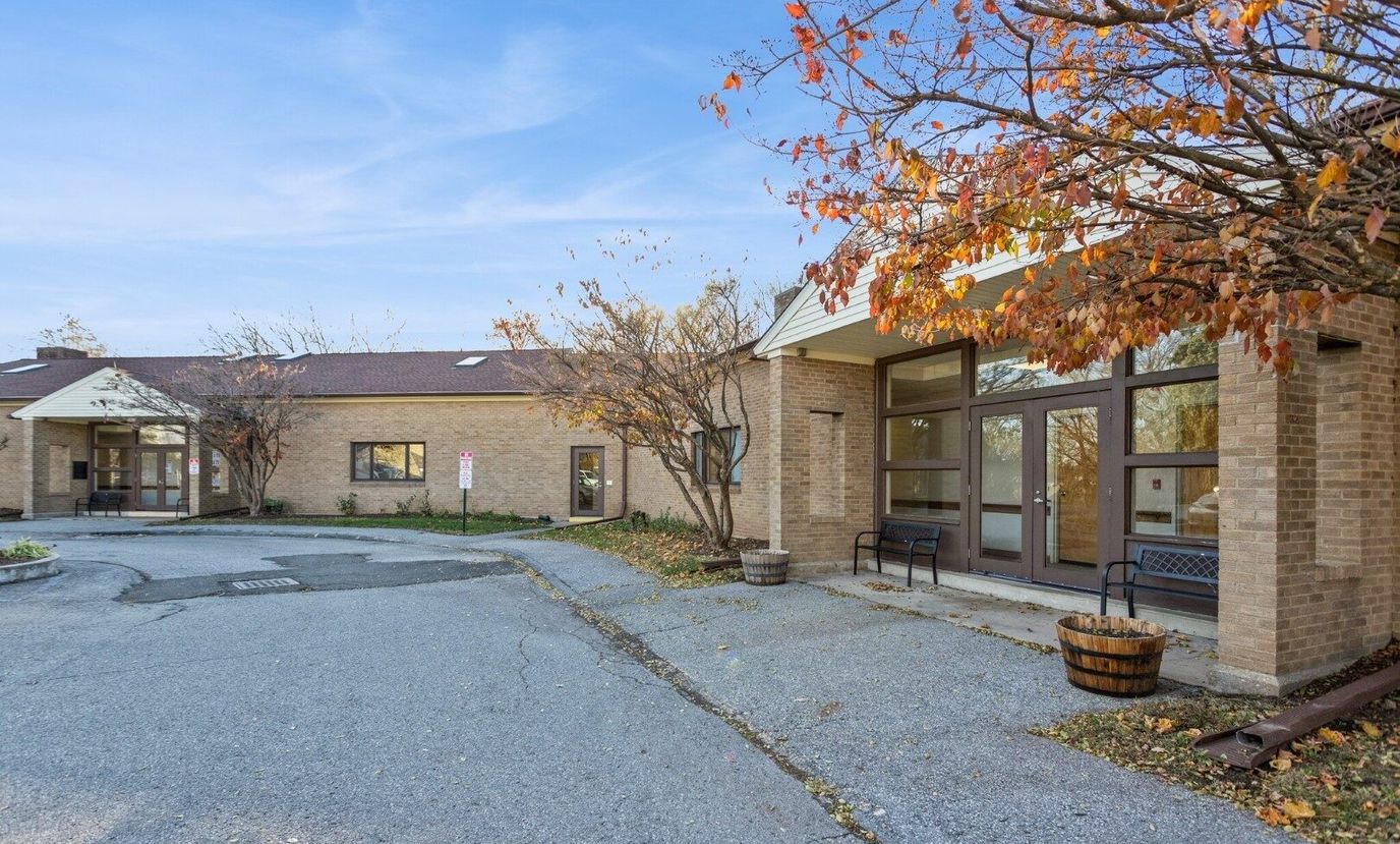 Exterior view of a senior living facility with autumn foliage