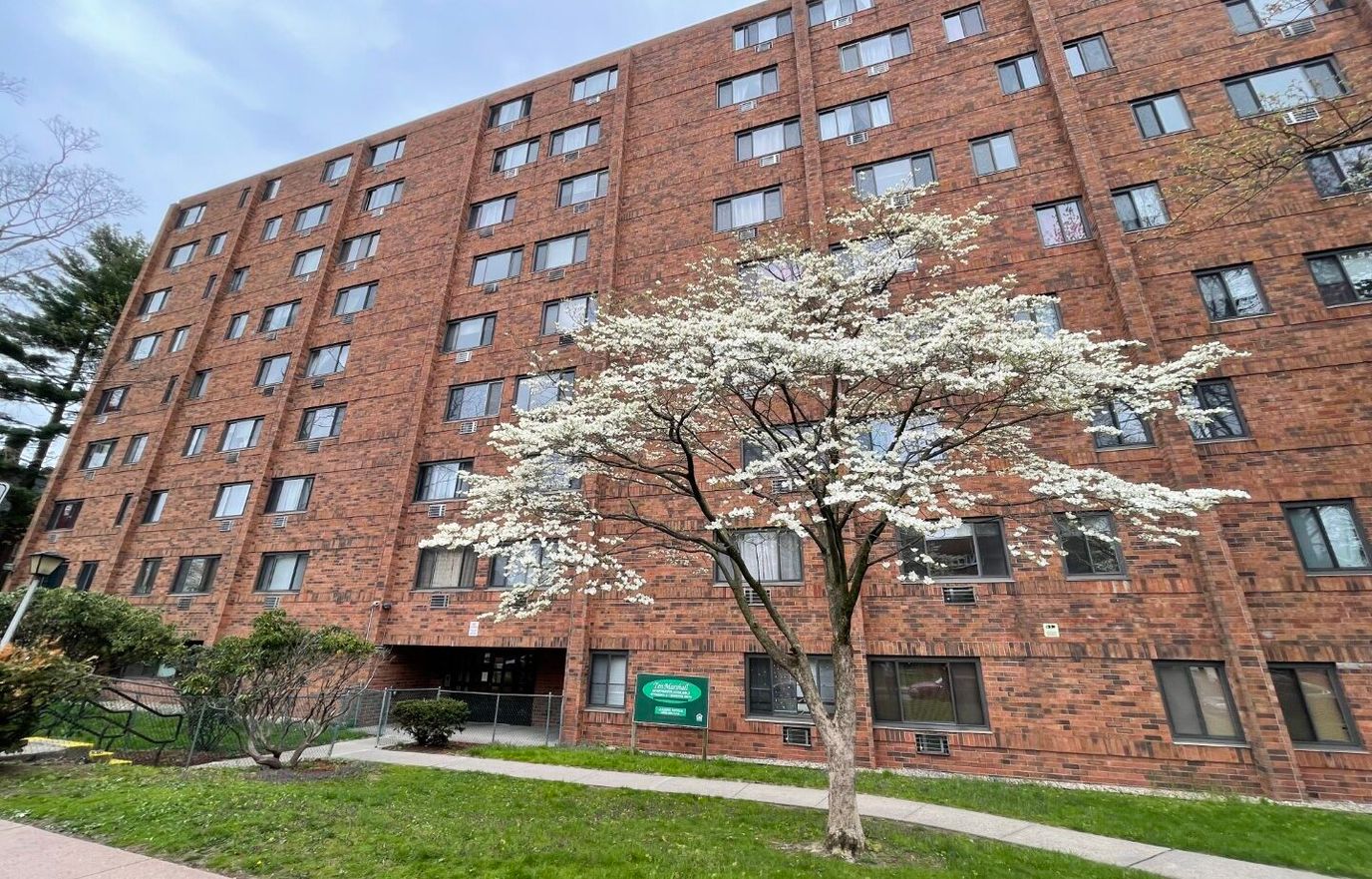 Exterior view of Marshall Apartments with blooming tree