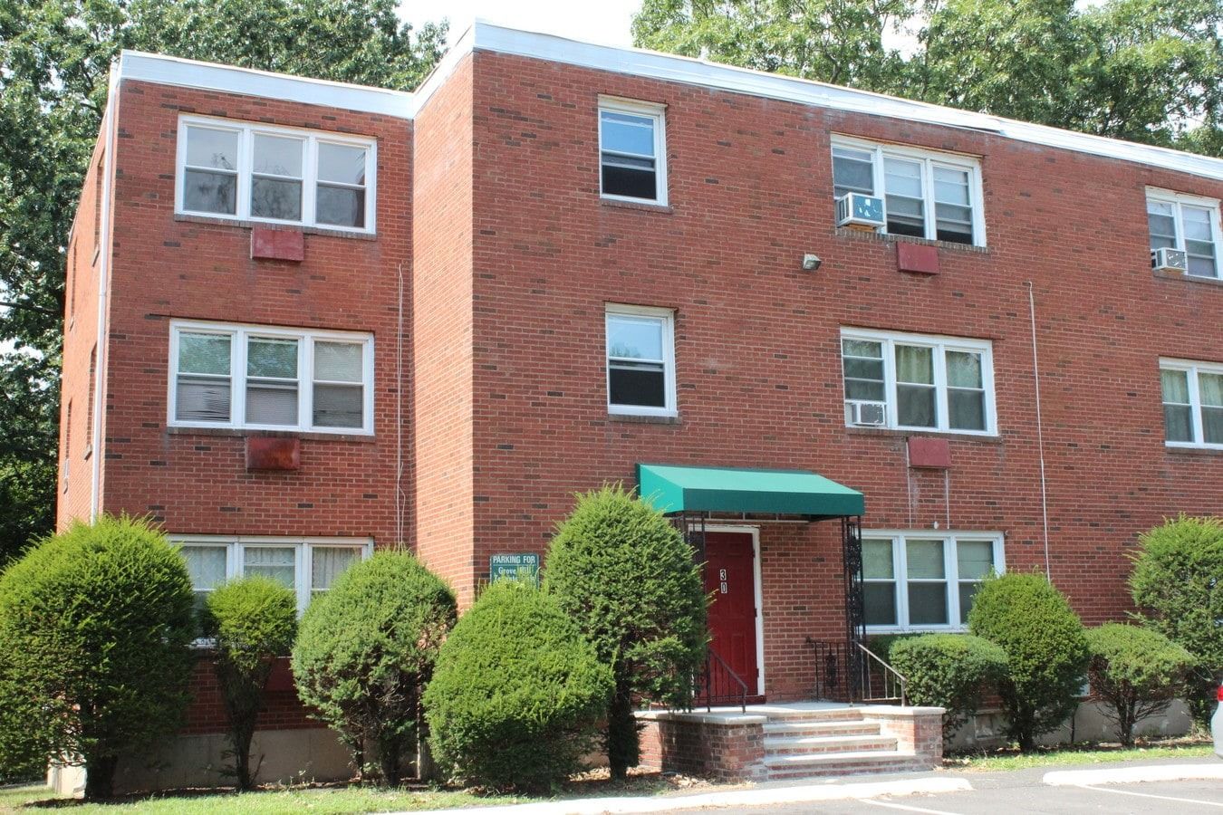 Exterior view of Grove Hill Apartments with landscaping