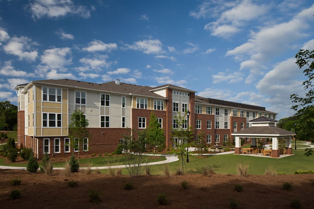Exterior view of a senior living facility with outdoor seating