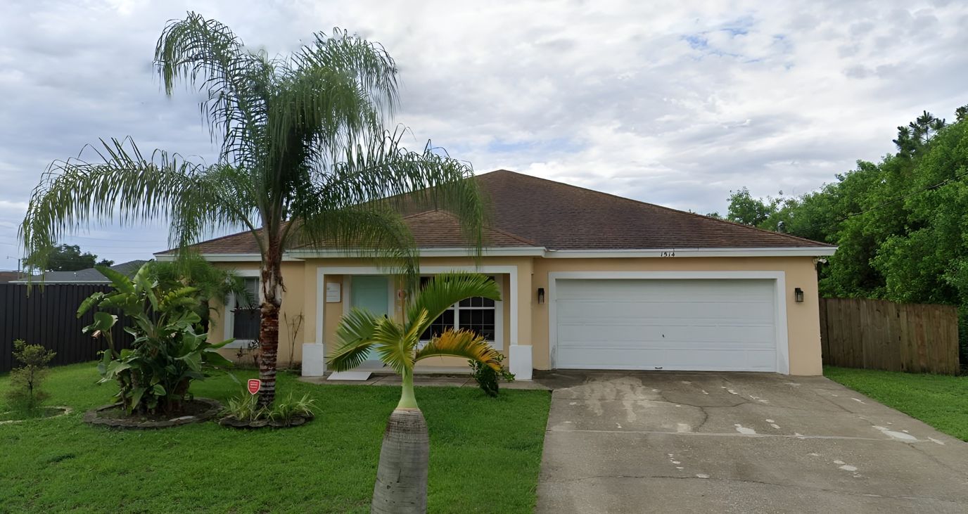 Exterior view of a senior living facility with palm trees