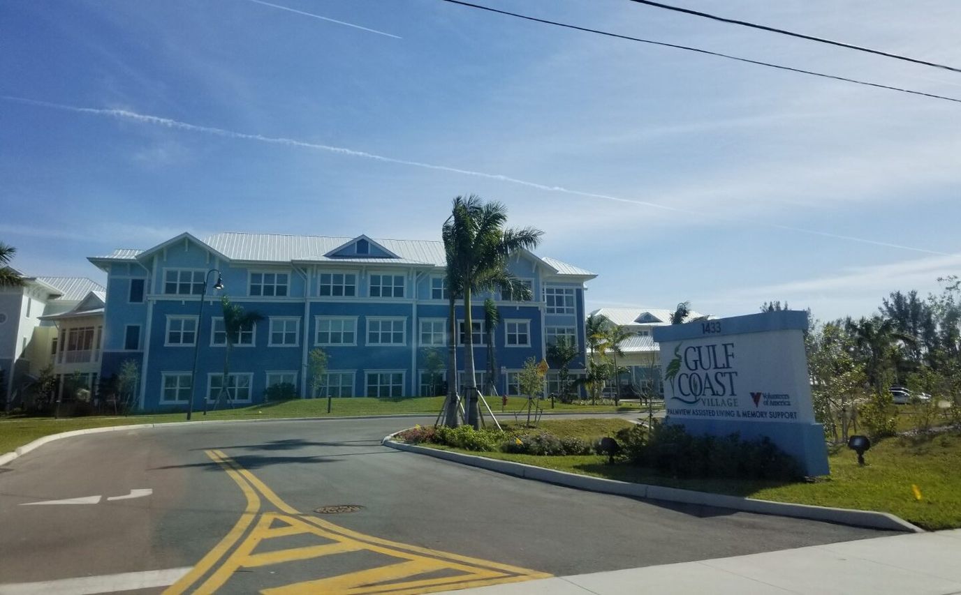 Exterior view of Gulf Coast Village building with landscaping