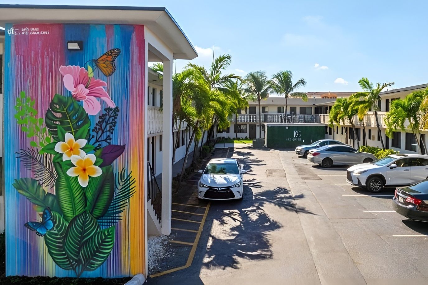 Exterior view of Plaza Gardenia Apartments with landscaping and parking