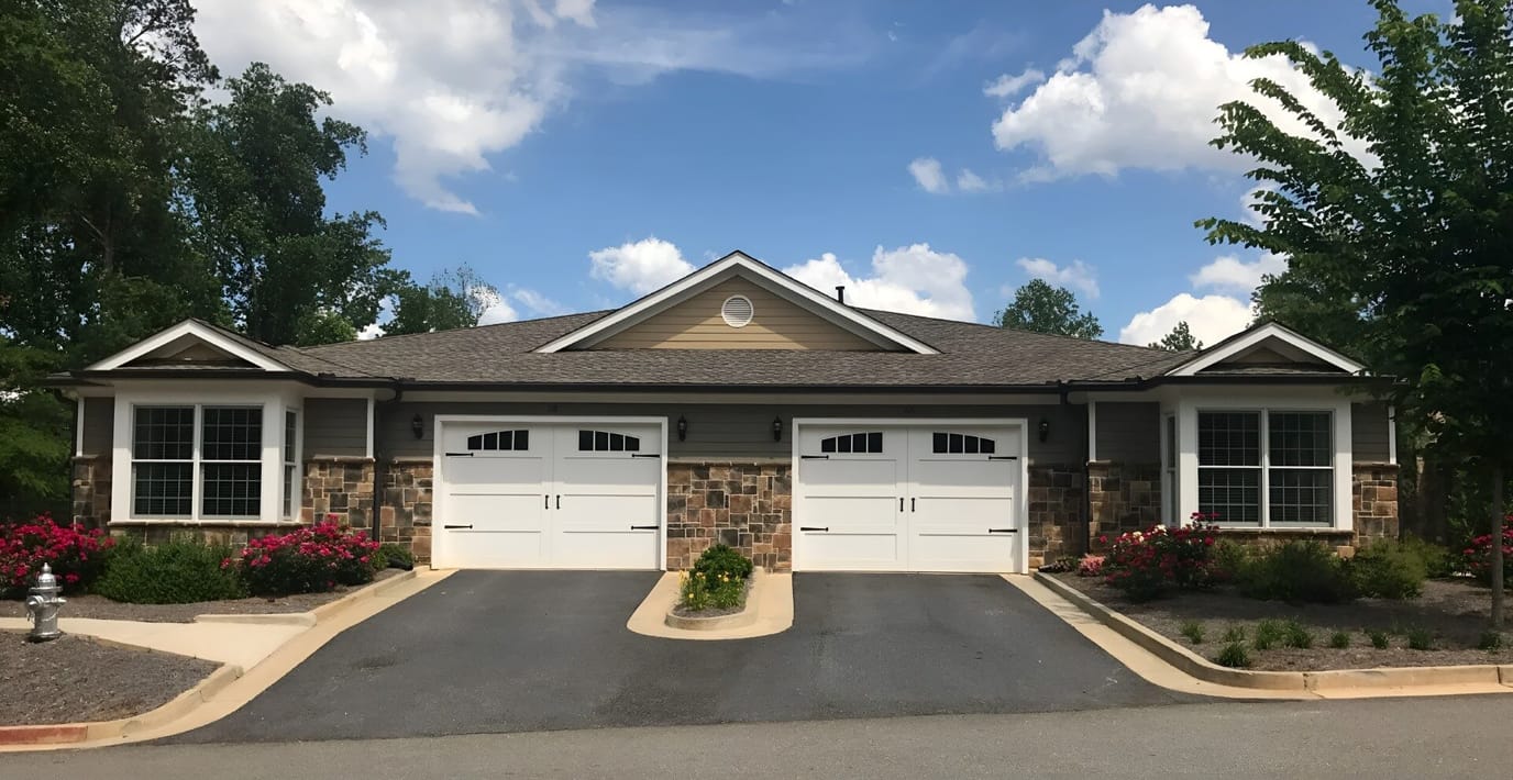 Exterior view of a senior living facility with garage doors