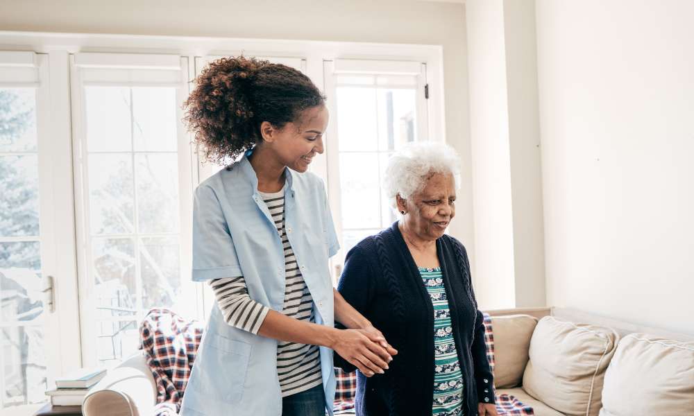 Caregiver assisting an elderly resident indoors.