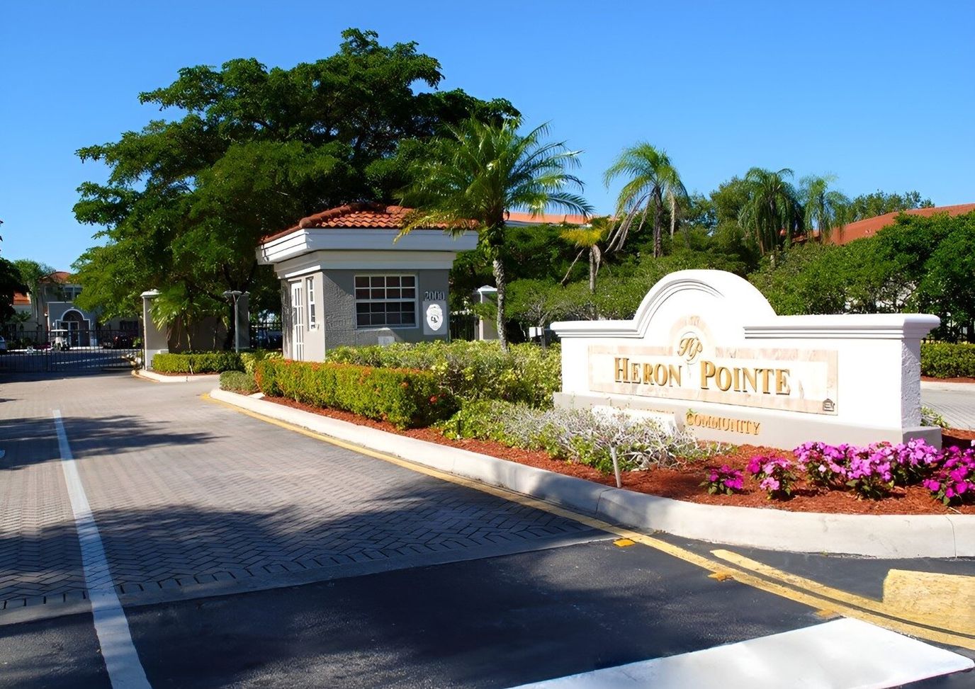Entrance view of Heron Pointe with flower beds and signage