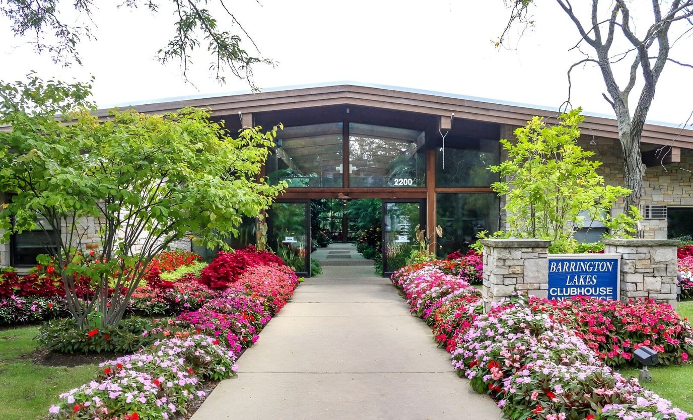 Entrance of Barrington Lakes Apartments surrounded by flowers