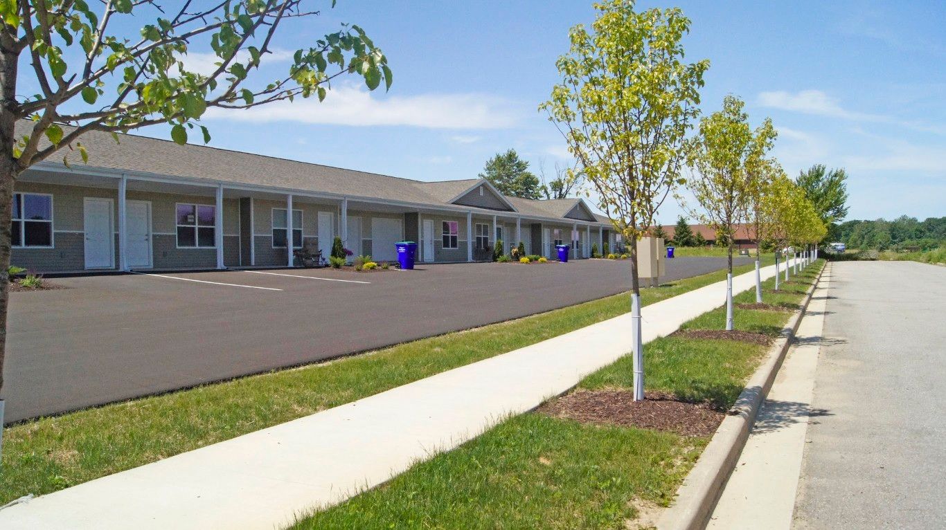 Exterior view of the assisted living facility with trees and a parking area