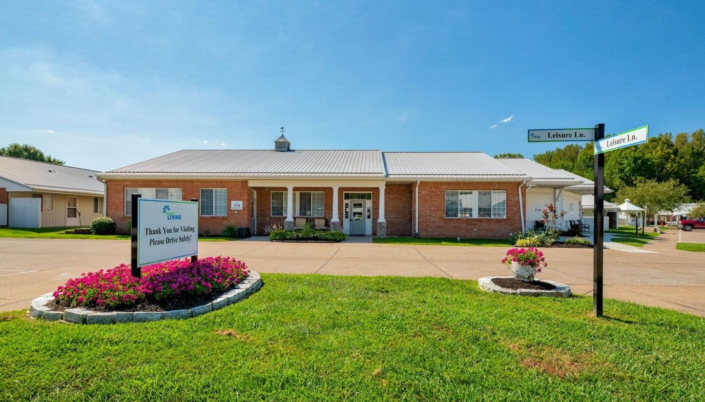 Exterior view of Leisure Living facility with signage and flowers