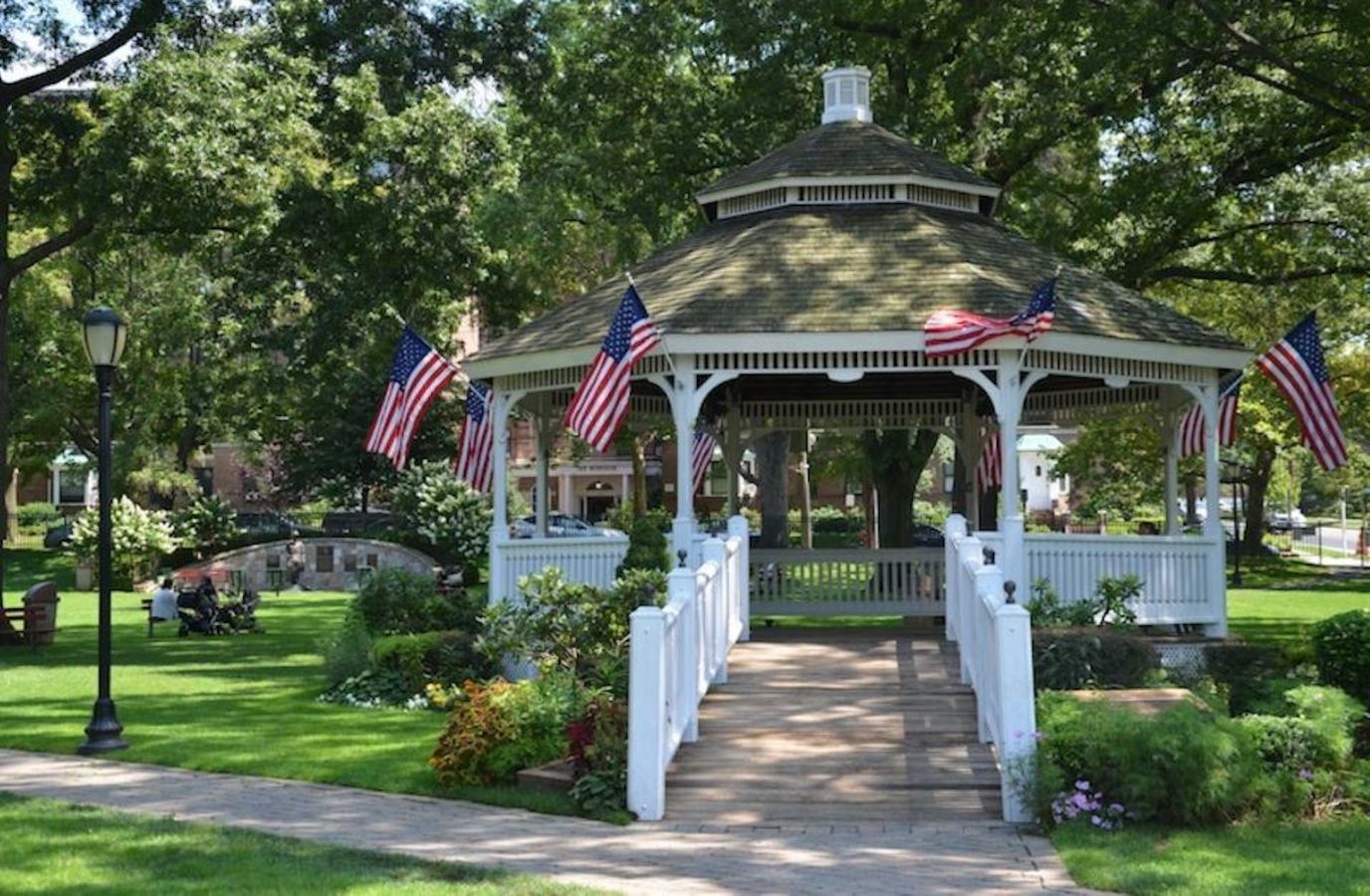 A gazebo in a park with American flags
