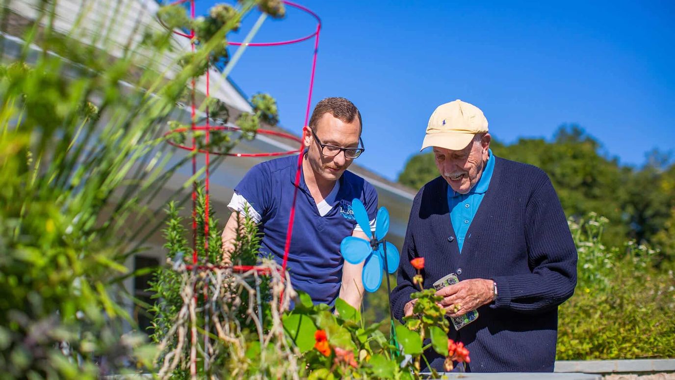 Staff and resident gardening in the facility outdoors