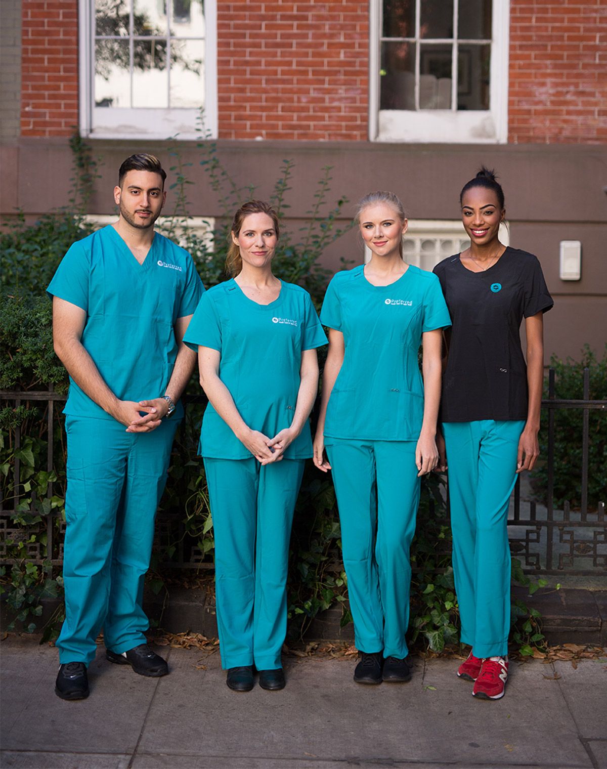 Staff members in teal scrubs outside the facility