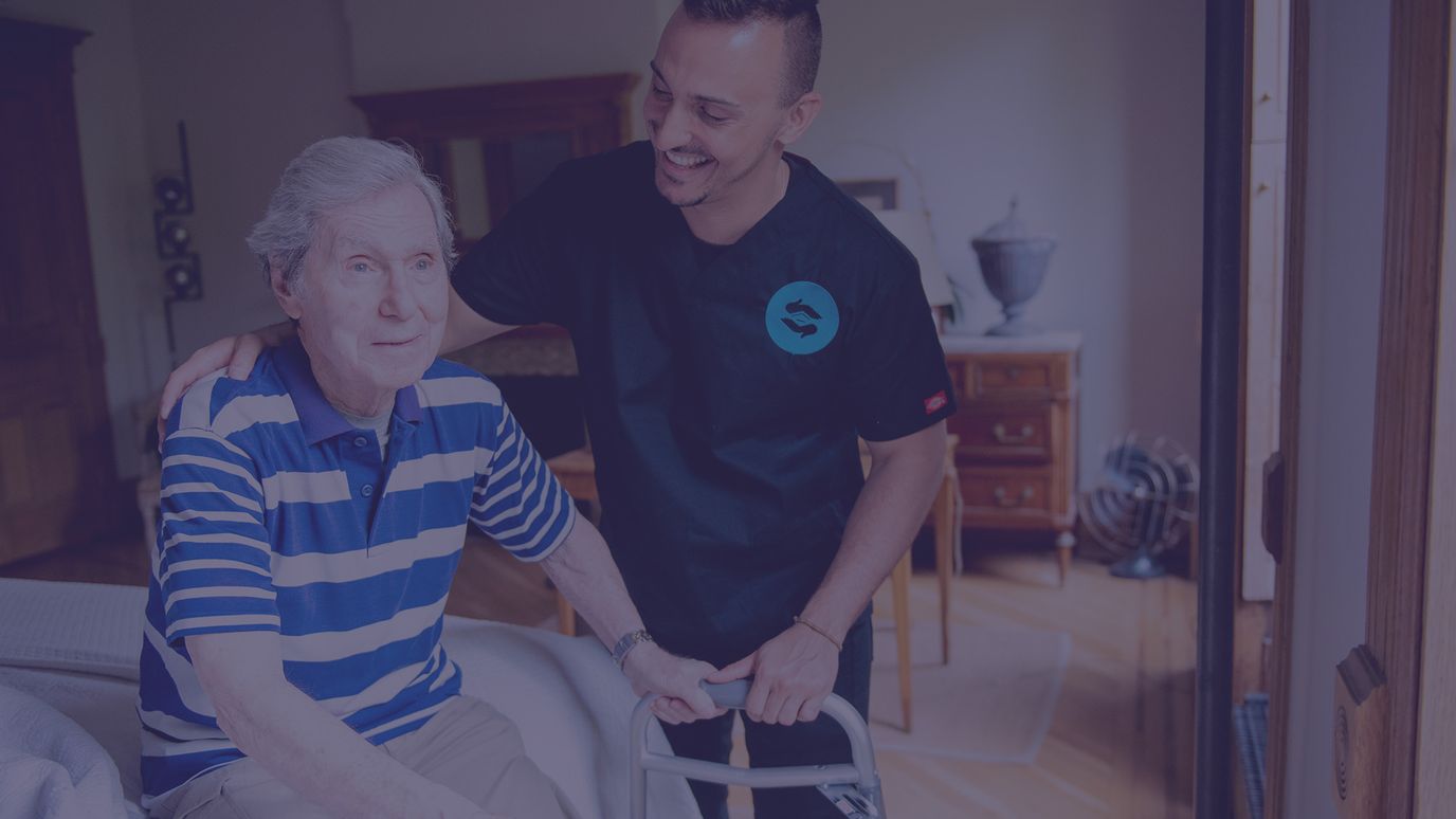 Caregiver assisting an elderly resident indoors.