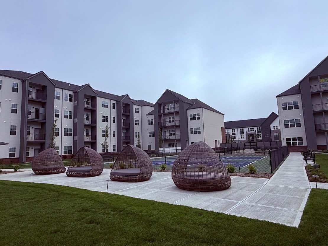 Outdoor seating area with modern architecture in the background.