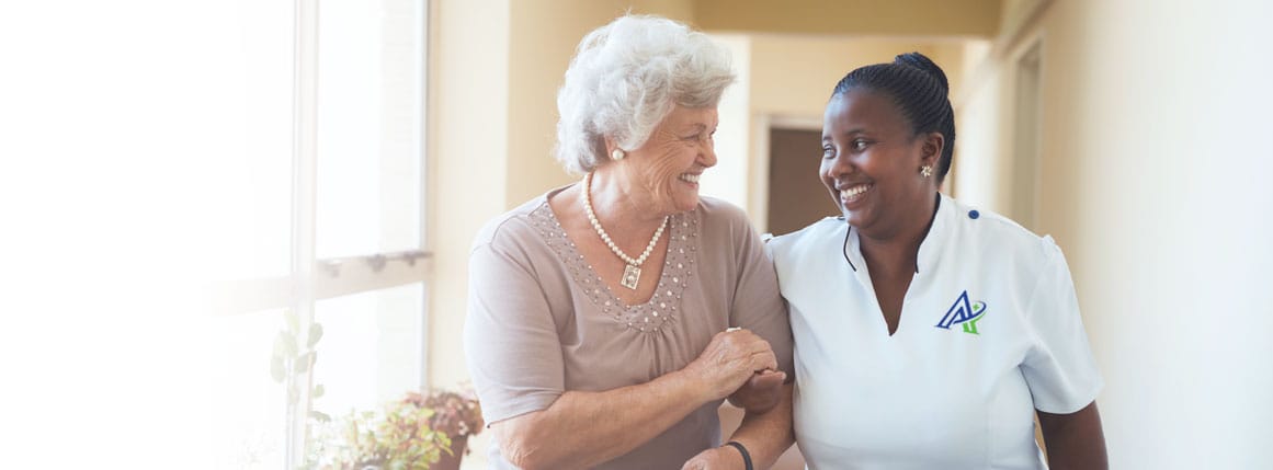 Care staff assisting a resident in a hallway
